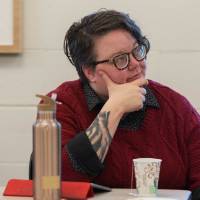 Krista Benson, assistant professor of liberal studies, listens intently to a presentation.